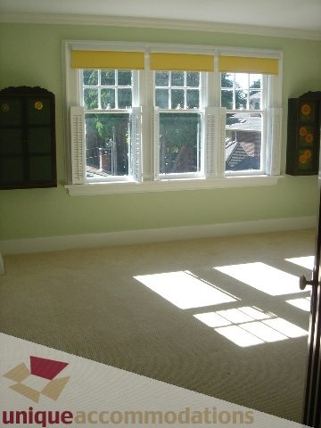 Bright bedroom with large windows, light green walls, and carpeted floor. - 1475 W 33rd Ave, Vancouver West Side