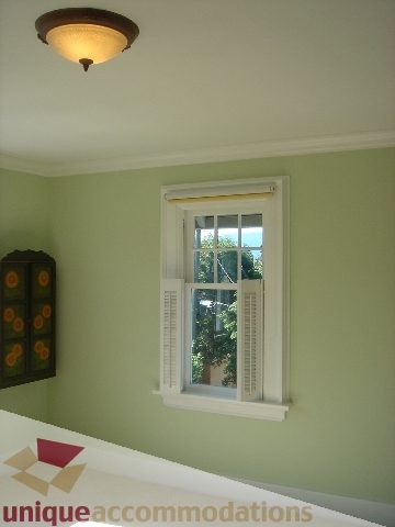Bright bedroom with light green walls, white trim, and a window with a yellow shade. - 1475 W 33rd Ave, Vancouver West Side