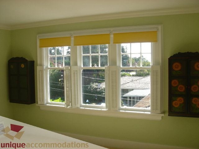 Bright living room with large bay window, yellow valance, and city view. - 1475 W 33rd Ave, Vancouver West Side