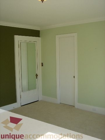 Bright living room with green walls and carpeted floor. - 1475 W 33rd Ave, Vancouver West Side