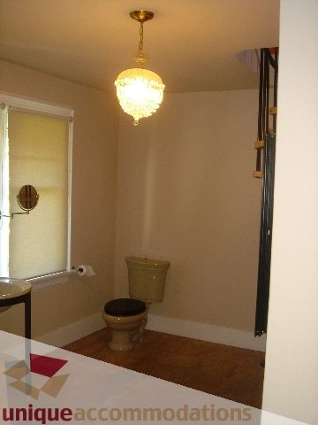 Bathroom with vintage toilet and chandelier, hardwood floors. - 1475 W 33rd Ave, Vancouver West Side