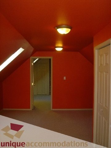 Attic bedroom with orange walls and a slanted ceiling. - 1475 W 33rd Ave, Vancouver West Side