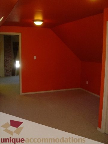 Bright living room with orange walls and carpeted floors. - 1475 W 33rd Ave, Vancouver West Side