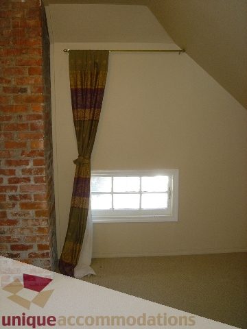 Attic bedroom with brick wall and small window, cozy and unique. - 1475 W 33rd Ave, Vancouver West Side