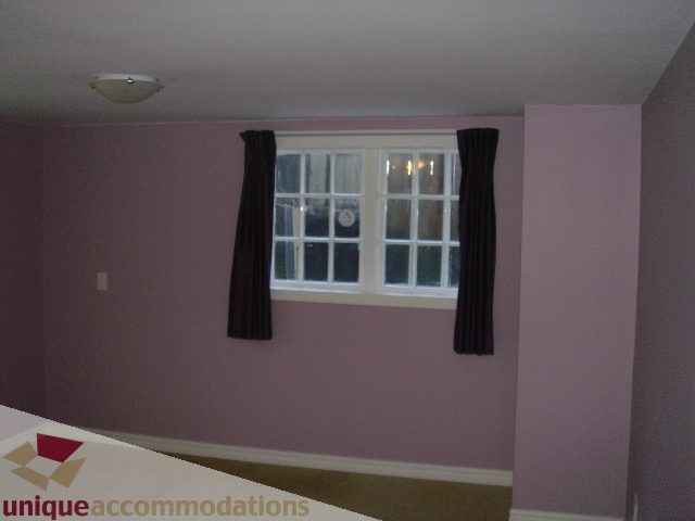Bright bedroom with purple walls, large window, and dark curtains. - 1475 W 33rd Ave, Vancouver West Side