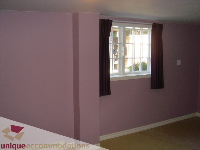 Living room with large window, purple walls, and beige carpet. - 1475 W 33rd Ave, Vancouver West Side