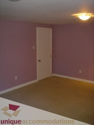 Empty bedroom with carpeted floor and white door. - 1475 W 33rd Ave, Vancouver West Side