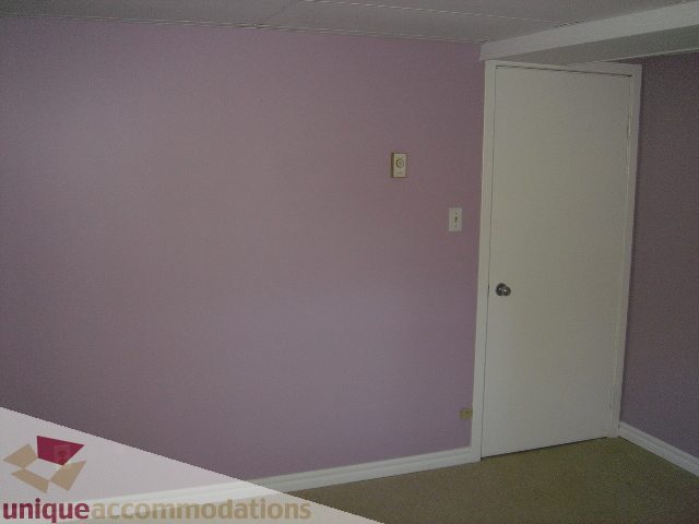 Bedroom with light purple walls, white trim, and a white door. - 1475 W 33rd Ave, Vancouver West Side