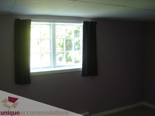 Bright living room with large window and green curtains. - 1475 W 33rd Ave, Vancouver West Side