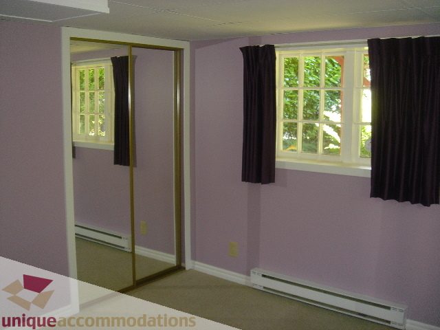 Bright living room with purple walls, large windows, and dark curtains. - 1475 W 33rd Ave, Vancouver West Side