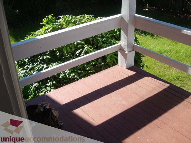 Furnished porch with wooden deck and lush greenery in the background. - 1475 W 33rd Ave, Vancouver West Side
