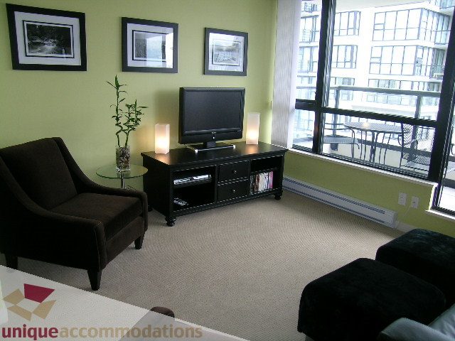 Living room with city view, modern furniture, and a flat-screen TV. - 2707 - 928 Homer Street, Vancouver Downtown
