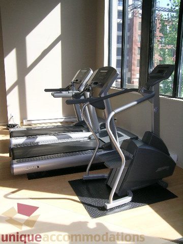 Bright exercise room with large windows, city view, and cardio equipment. - 2707 - 928 Homer Street, Vancouver Downtown
