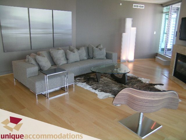 Furnished living room with hardwood floors, modern furniture, and a fireplace. - 1603-1650 Bayshore Drive, Vancouver Downtown