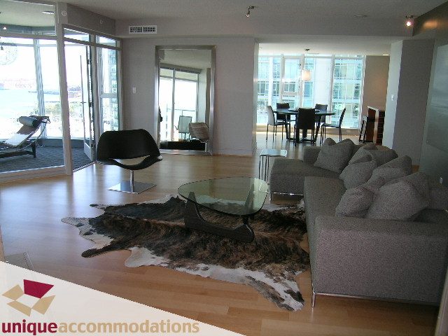 Spacious living room with hardwood floors, cowhide rug, and city view. - 1603-1650 Bayshore Drive, Vancouver Downtown