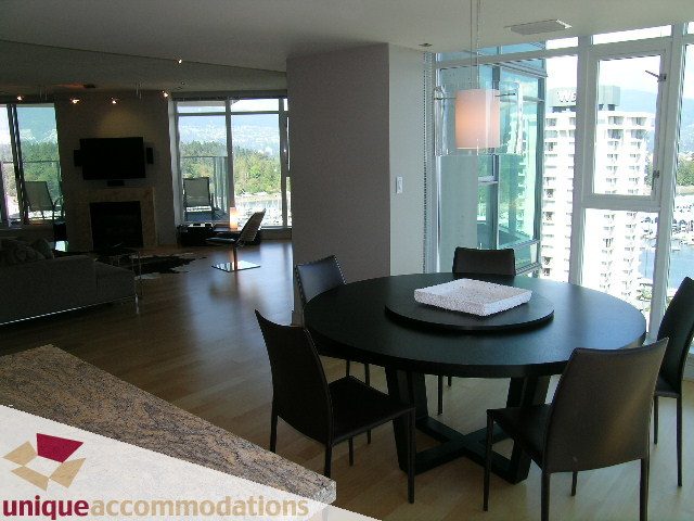 Furnished dining area with hardwood floors, city view, and modern decor. - 1603-1650 Bayshore Drive, Vancouver Downtown