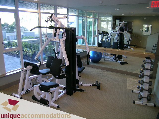 Bright gym with large windows, exercise equipment, and city view. - 1603-1650 Bayshore Drive, Vancouver Downtown