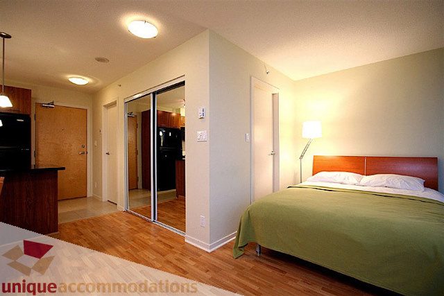 Furnished bedroom with hardwood floors and a cozy ambiance. - 1207 - 1155 Seymour Street, Vancouver Downtown