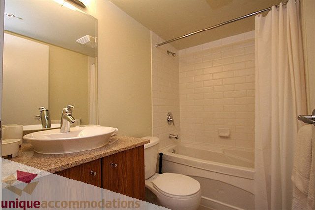 Furnished bathroom with granite countertops and white subway tile shower. - 1207 - 1155 Seymour Street, Vancouver Downtown