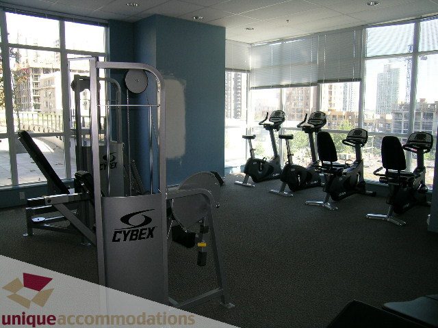 Furnished gym with Cybex equipment and city view windows. - 1207 - 1155 Seymour Street, Vancouver Downtown