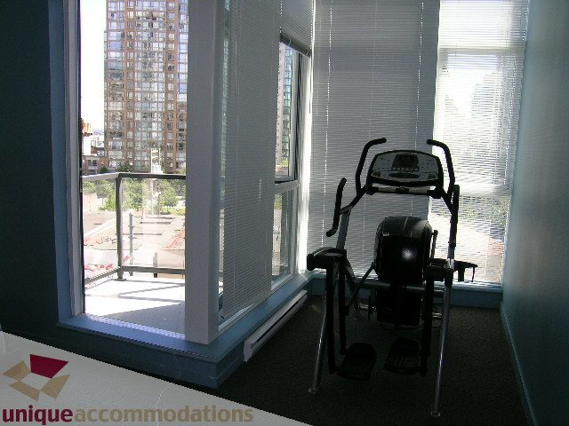 Bright living room with city view and exercise equipment. - 1207 - 1155 Seymour Street, Vancouver Downtown
