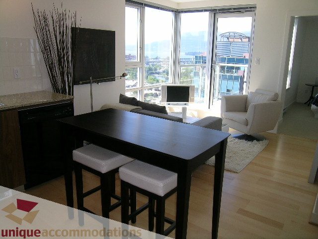 Spacious living room with hardwood floors, city view, and modern furnishings. - 1204-1030 West Broadway, Vancouver West Side