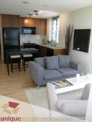 Spacious living room with hardwood floors, modern furnishings, and a cozy corner sofa. - 1204-1030 West Broadway, Vancouver West Side