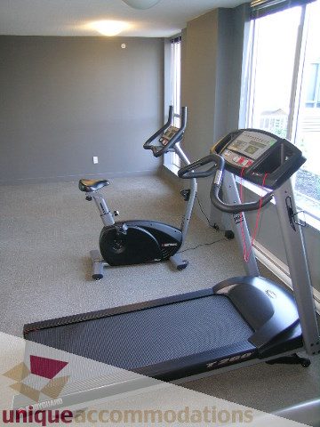Bright exercise room with treadmill and stationary bike, natural light from large windows. - 1204-1030 West Broadway, Vancouver West Side