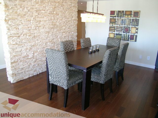 Furnished dining area with stone accent wall and hardwood floors. - 602-1012 Beach Ave., Vancouver Downtown