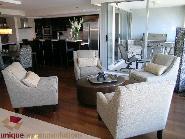 Spacious living room with modern furniture, hardwood floors, and a view of the city. - 602-1012 Beach Ave., Vancouver Downtown