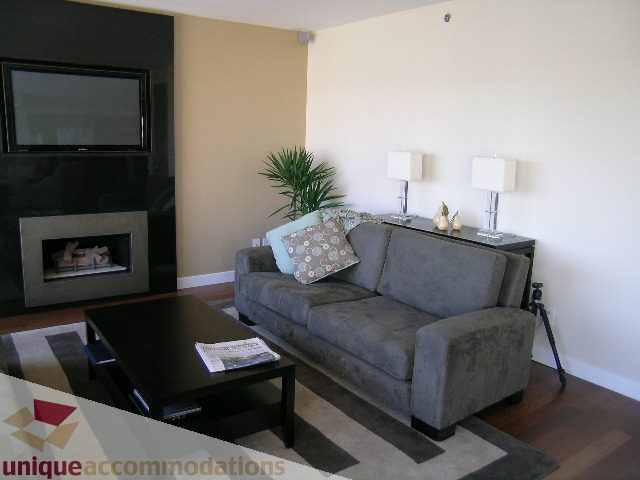 Furnished living room with modern furniture, fireplace, and large windows. - 602-1012 Beach Ave., Vancouver Downtown