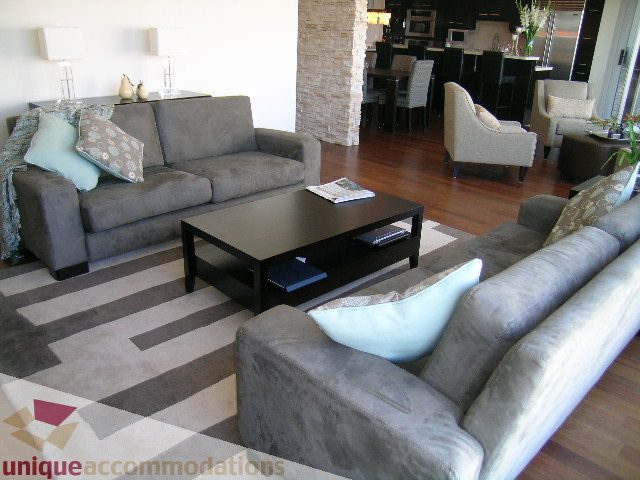 Furnished living room with modern furniture, hardwood floors, and a cozy ambiance. - 602-1012 Beach Ave., Vancouver Downtown