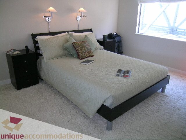 Bright bedroom with queen bed, plush carpet, and window view. - 602-1012 Beach Ave., Vancouver Downtown