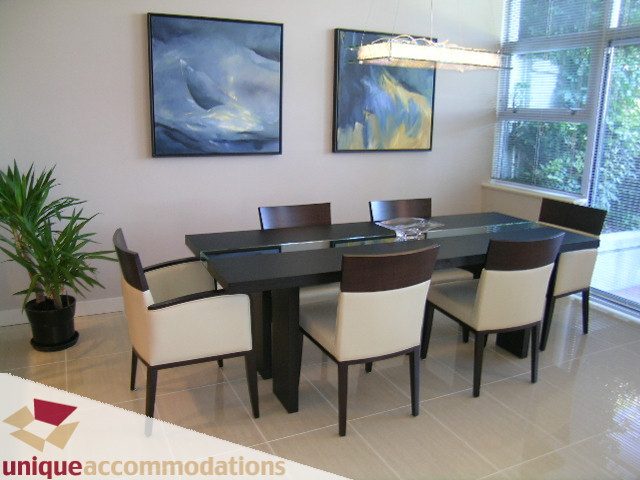 Spacious dining area with modern chairs and abstract wall art, perfect for entertaining. - 103-638 Beach Cres., Vancouver Downtown