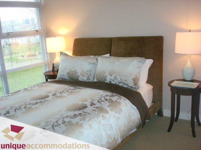 Spacious bedroom with plush bedding, city view, and modern decor. - 103-638 Beach Cres., Vancouver Downtown