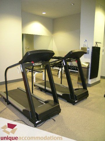 Spacious fitness room with treadmills and mirrors, perfect for workouts. - 103-638 Beach Cres., Vancouver Downtown