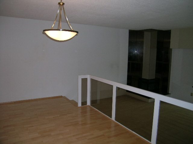Bright living room with hardwood floors and a modern chandelier. - 147 - 3300 Capilano Rd, North Vancouver