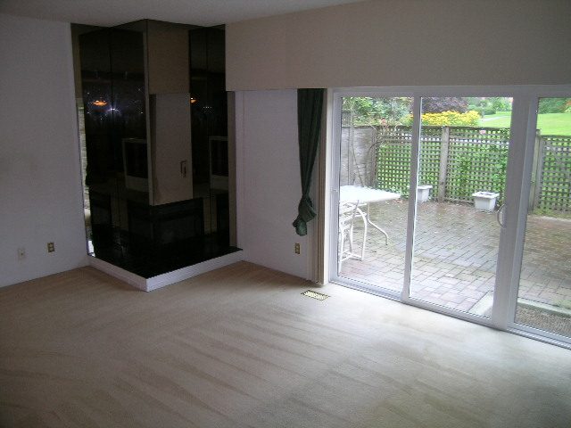 Bright living room with hardwood floors and sliding glass doors leading to a garden. - 147 - 3300 Capilano Rd, North Vancouver