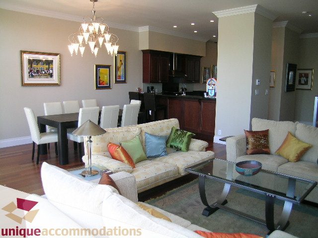 Open-concept living and dining area with hardwood floors, modern furnishings, and a chandelier. - 103 - 1515 Homer Mews, Vancouver Downtown