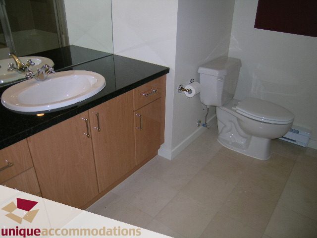 Bathroom with black countertops and white fixtures. - 163 Aquarius Mews, Vancouver Downtown