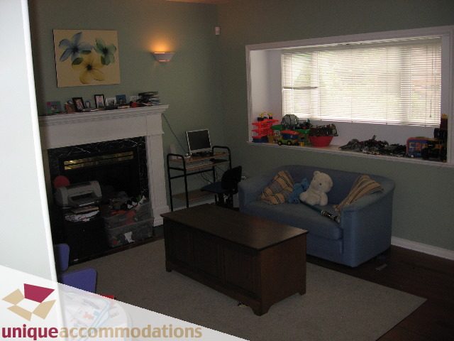 Living room with fireplace, toys on window sill, hardwood floors. - 4217 West 14th Avenue, Vancouver West Side