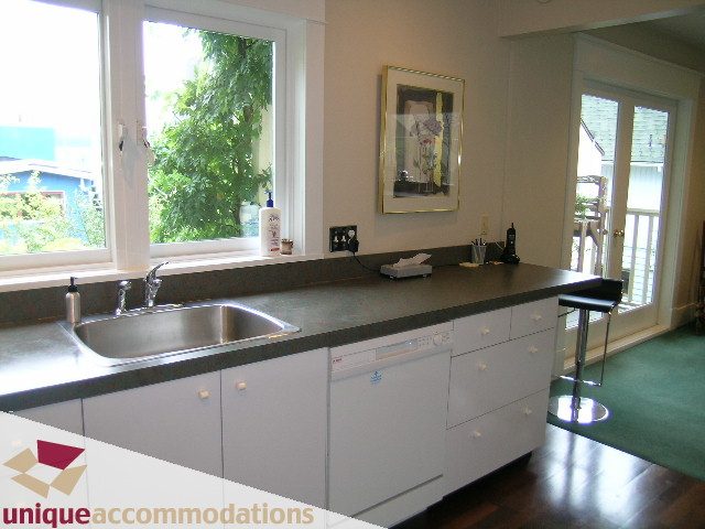Bright kitchen with modern countertops, hardwood floors, and a city view. - 3447 West 1st Avenue, Vancouver West Side