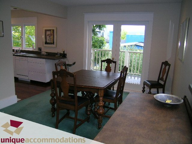 Furnished dining area with hardwood floors, large windows, and a city view. - 3447 West 1st Avenue, Vancouver West Side