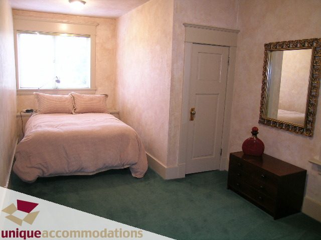 Furnished bedroom with pink bedding and green carpet. - 3447 West 1st Avenue, Vancouver West Side