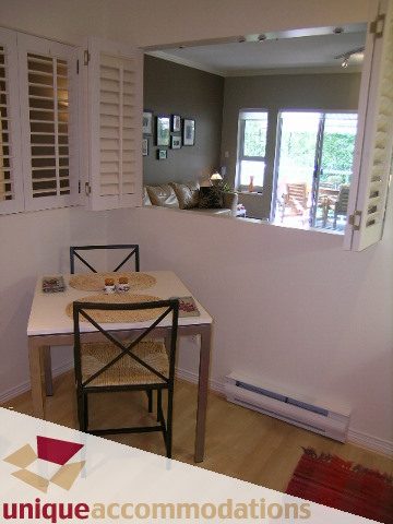 Furnished living room with hardwood floors and sliding glass door leading to a patio. - 304 - 1281 Parkgate Avenue, North Vancouver