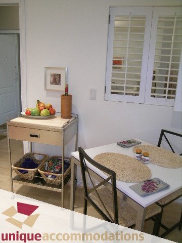 Furnished living room with modern decor, fruit bowl, and white shutters. - 304 - 1281 Parkgate Avenue, North Vancouver
