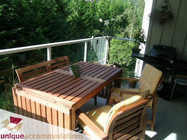 Furnished balcony with wooden furniture and a view of greenery. - 304 - 1281 Parkgate Avenue, North Vancouver