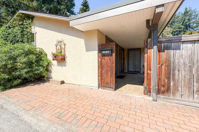 Furnished house entryway with brick driveway, wooden gate, and potted flowers. - Address WITHHELD, North Vancouver
