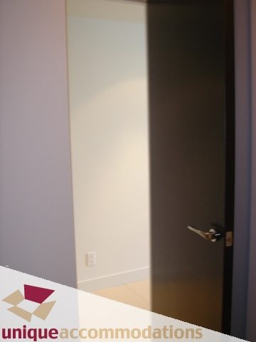 Spacious living room with large windows and a modern door. - 1101 -1455 Howe Street, Vancouver Downtown