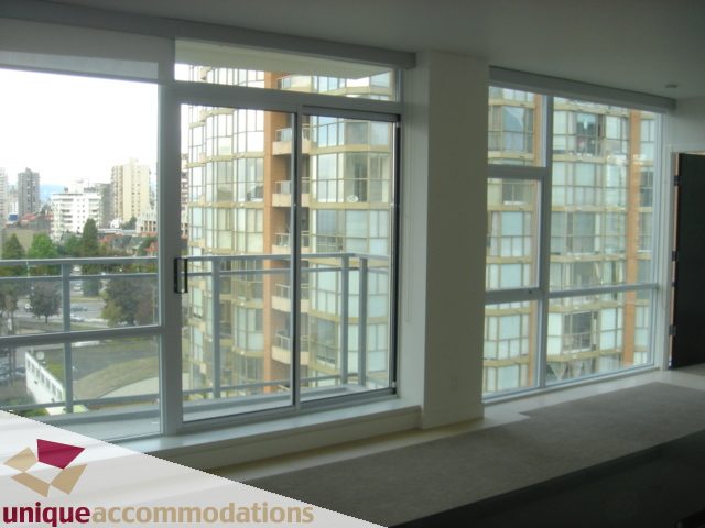 Spacious living room with large windows offering a stunning city view. - 1101 -1455 Howe Street, Vancouver Downtown